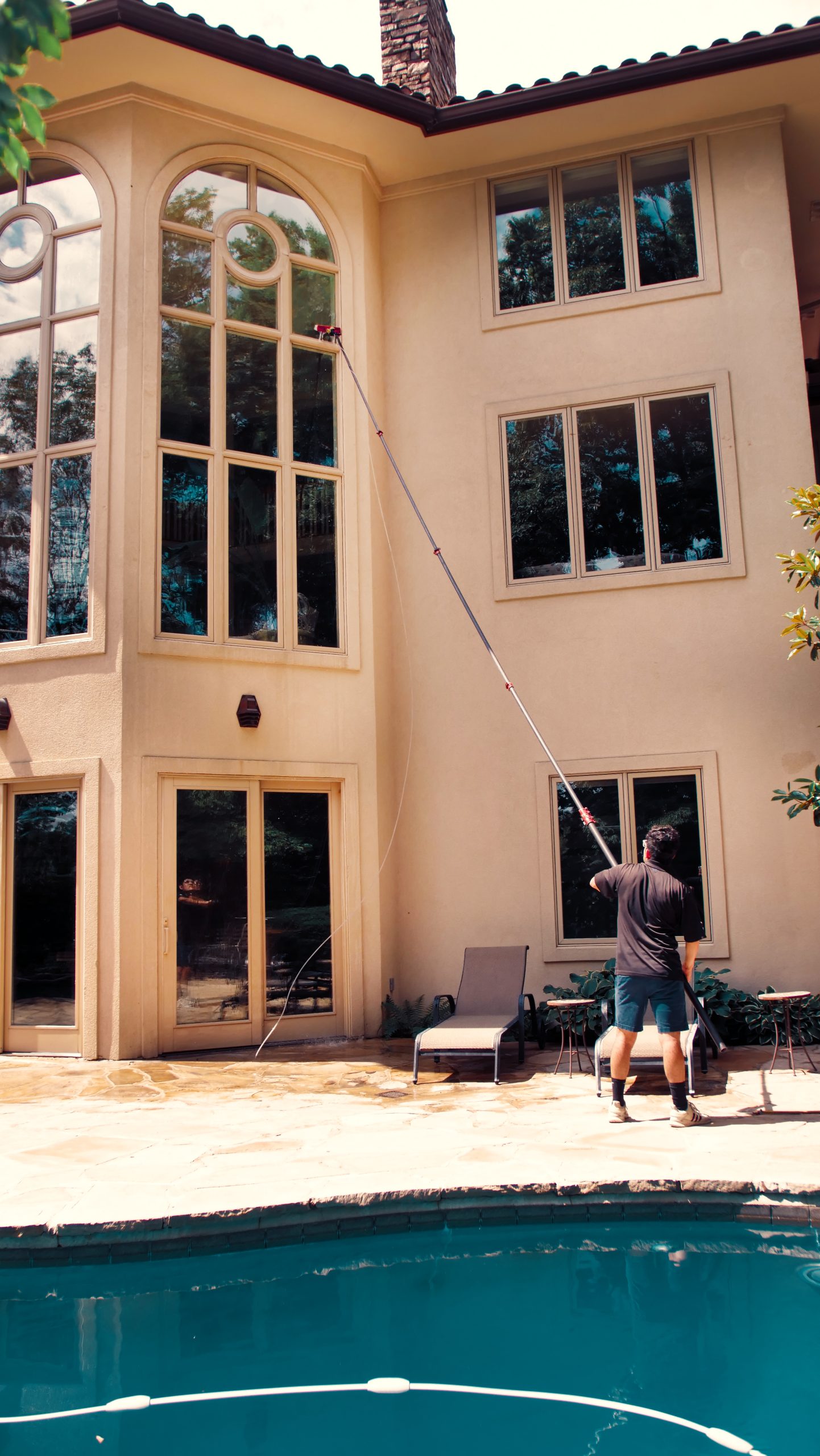 Using extension pole to clean high to reach windows
